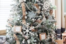 24 a flocked Christmas tree with oversized snowflake ornaments, burlap ribbons, greenery and mini frames for decor
