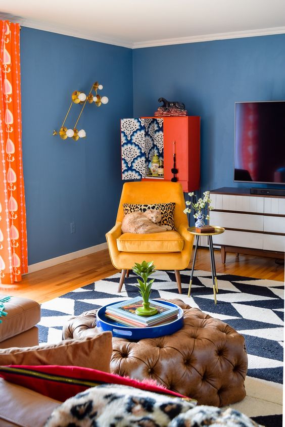 a super bright and fun living room with blue walls, colorful furniture and accessories plus textiles