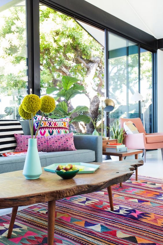 a colorful living room with bright furniture, rugs and pillows and porcelain