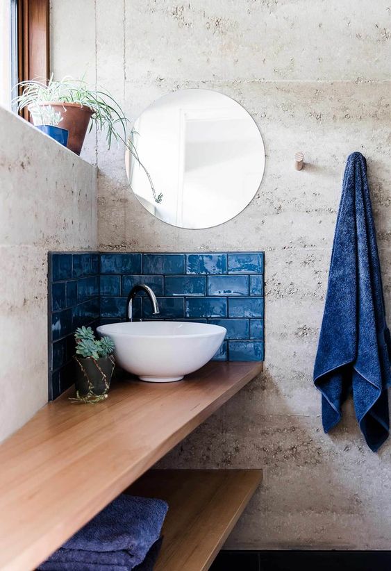 a small classic blue tile backsplash aroudn the sink and some matching towels for a bold touch in the bathroom