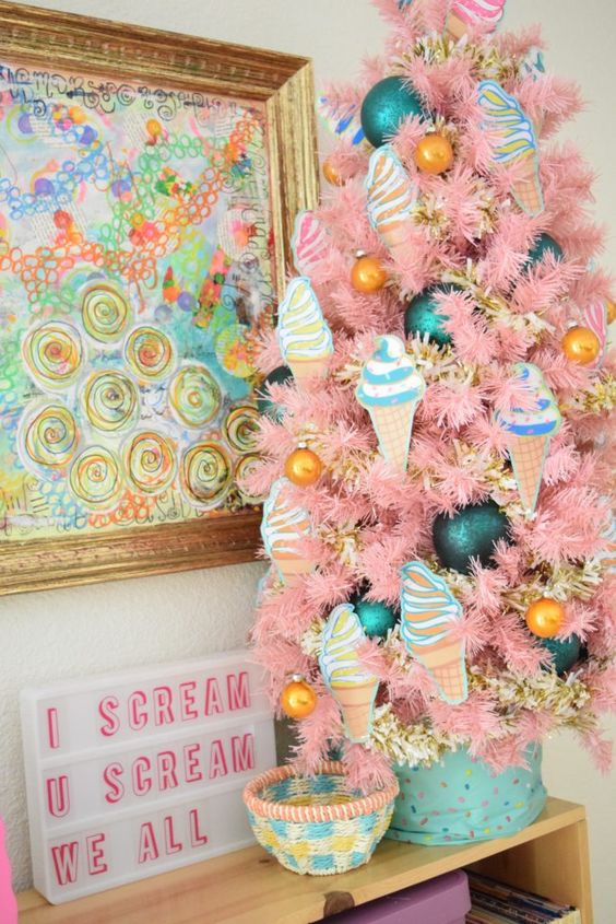 a tabletop pink Christmas tree with ice cream ornaments, marigold and teal ones of various sizes