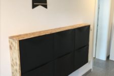 25 an IKEa Trones cabinet in black with a light-colored waterfall wooden countertop is a contemporary or minimalist idea