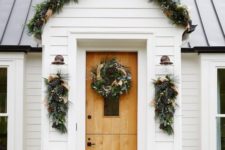 25 an evergreen garland with pinecones and burlap ribbons covering the porch and posies and wreaths that match
