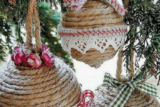25 rope wrapped Christmas ball ornaments done with plaid ribbons and bows and crochet lace is a pretty vintage and rustic idea