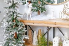 Christmas console decor with flocked Christmas trees, cone trees, deer and pinecones in a box is amazing