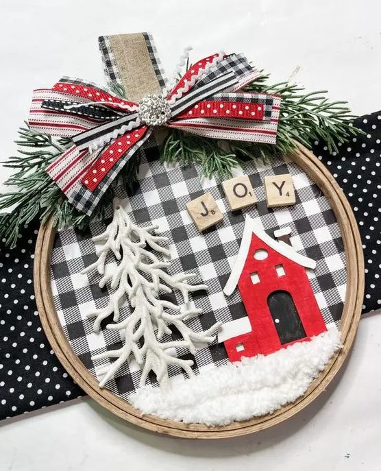a cool embroidery hoop Christmas ornament with buffalo check, a red house and letters, a Christmas tree and a bow on top