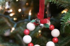 a cute and easy rustic Christmas ornament of red and white beads, bells and a red bow is a cool idea for styling a tree