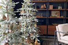 a duo of large Christmas trees with green and brown ornaments and baskets is a cool decor idea for the holidays