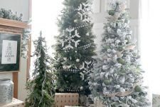 a farmhouse Christmas tree display with trees decorated in various ways and some gift boxes under the trees