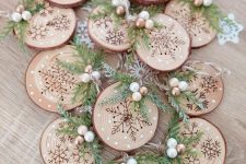 beautiful tree slice Christmas ornaments with wood burnt snowflakes, wooden beads and evergreens are awesome