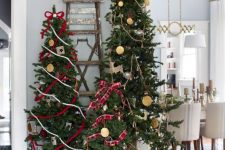 multiple Christmas trees decorated with ribbons, ornaments and stars on top are amazing for bold rustic decor