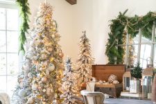 multiple flocked Christmas trees with lights, metallic and white ornaments are perfect for rustic holiday decor