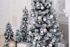 multiple flocked Christmas trees with metallic and white ornaments, lanterns and gift boxes are amazing