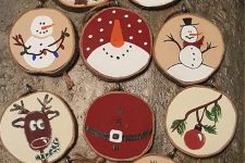 various painted wood slice ornaments that include snowmen, stockings, deer and trees