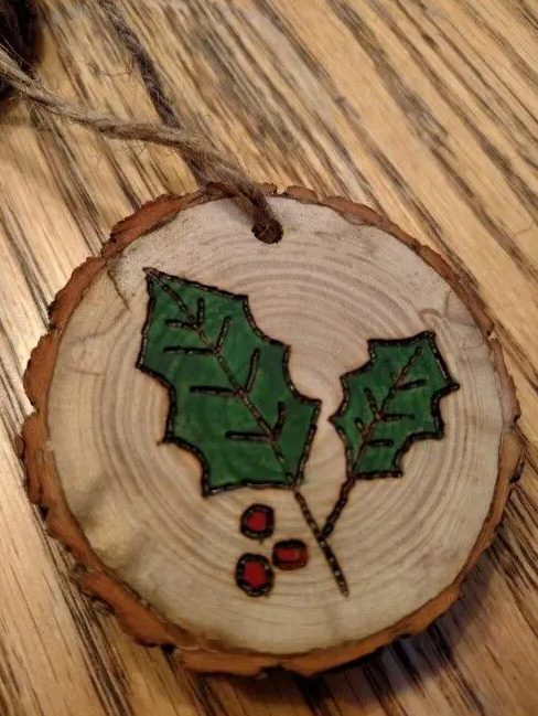 wood burnt and painted mistletoe wood slice ornaments with a strong rustic feel