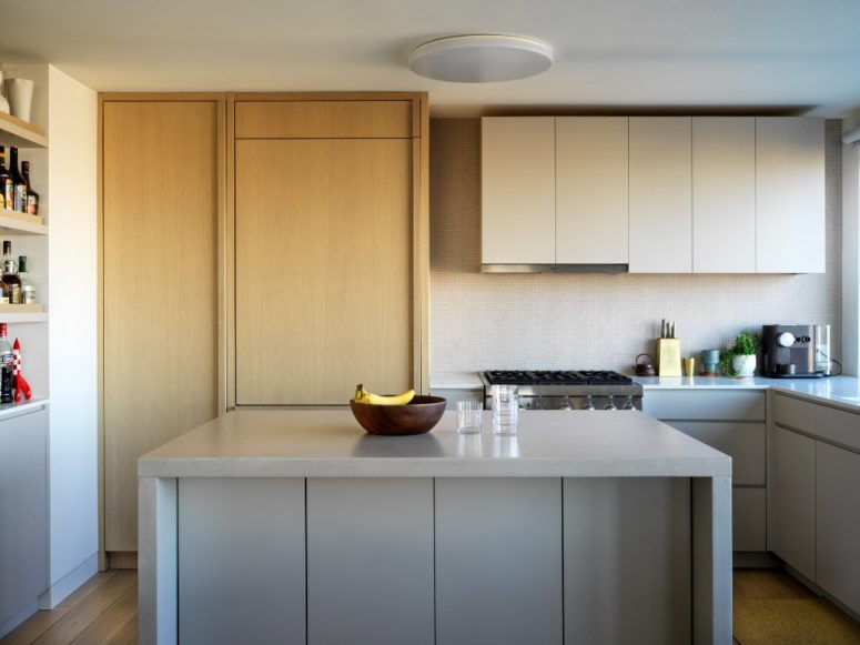 The kitchen is done in neutrals, with sleek surfaces, comfortable shelving and mostly hidden storage units