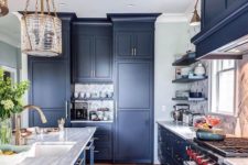 02 a classic navy kitchen with sleek cabinets, metal handles, stone countertops and chic and refined lamps