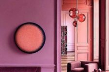 02 a pink space with molding, an elegant velvet sofa and chic spheric lamps plus parquet floors
