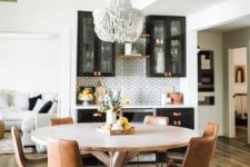 03 a round wooden table with leather chairs and a statement bead chandelier create an informal dining space