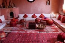 04 a bold red space done with Moroccan touches – patchwork poufs, striped pillows, a large hearth with musical instruments on the mantel