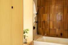 05 The bathroom features much storage space hidden within the wardrobes and tiles of a very quirky earthy shade