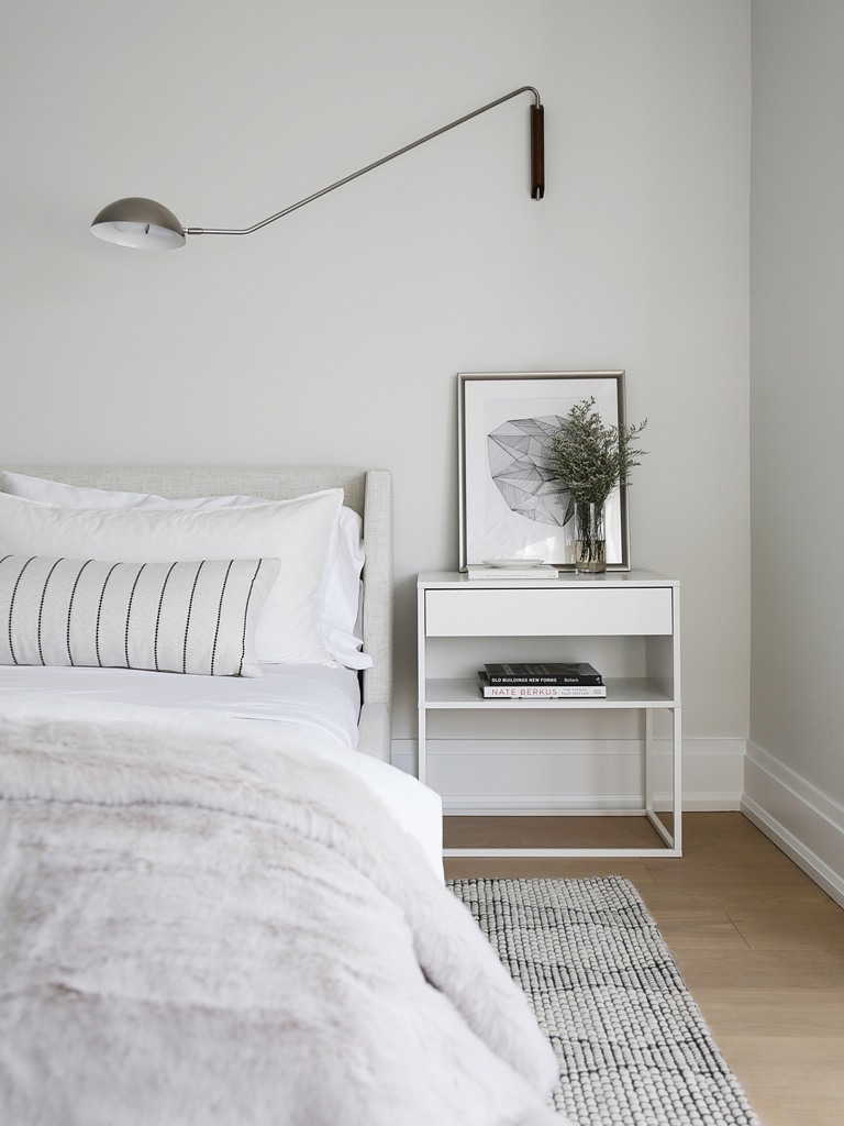 The bedroom is all neutral, with some prints and simple and stylish furniture