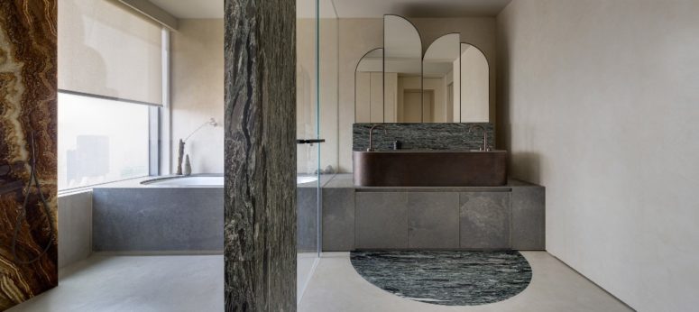 The bathroom features truly wabi-sabi, with wooden and marble pillars a stone clad tub and timber