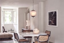 07 The dining space is done with a marble table and wicker chairs, there’s a chic lamp