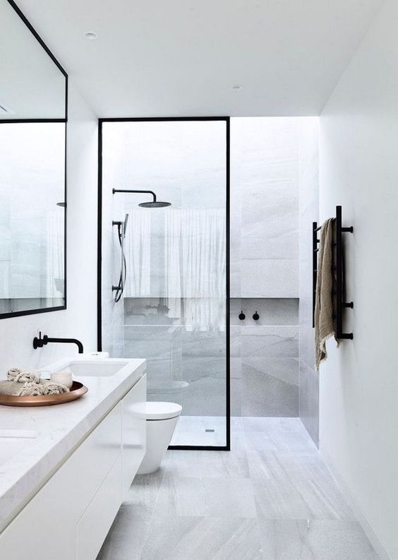 a stylish minimmalist bathroom done with grey marble tiles and touches of black for drama