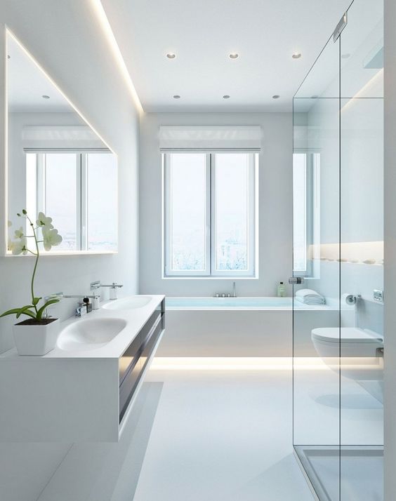 A super clean and sleek white minimalist bathroom with built in lights, a large window and a floating vanity