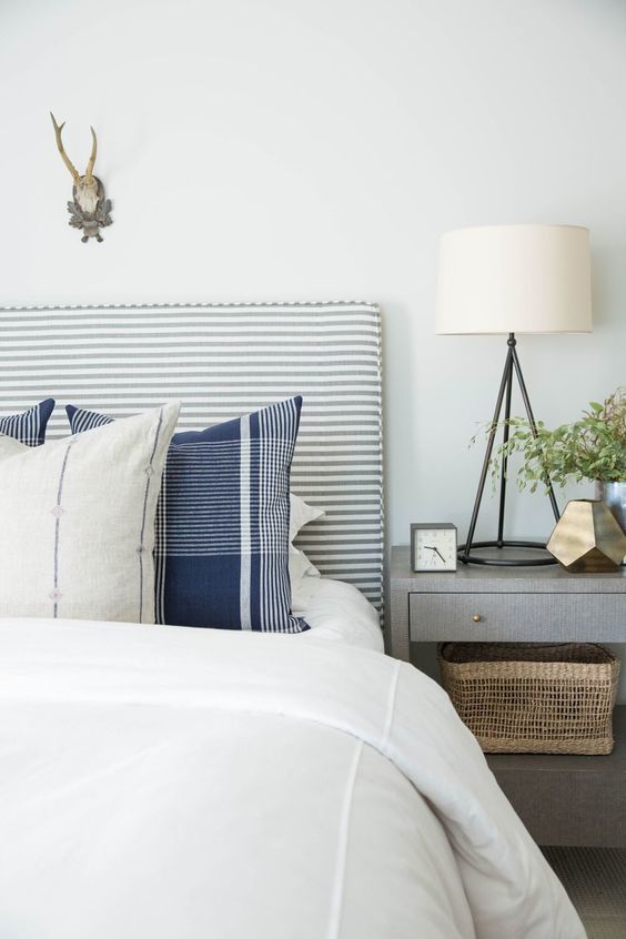 a cool striped grey and white upholstered headboard is a nice fit for many bedrooms including this rustic one