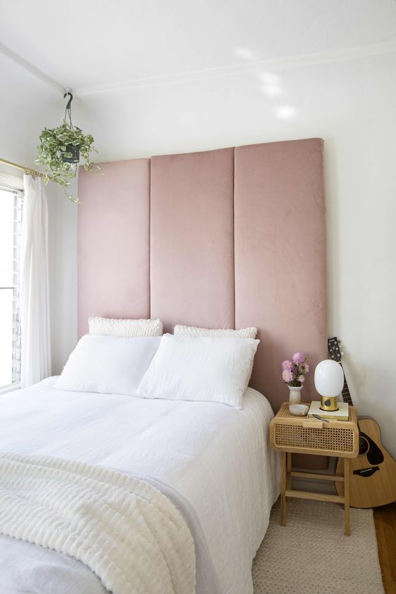 a statement blush pink upholstered headboard is a tender and sweet statement that takes over the whole space