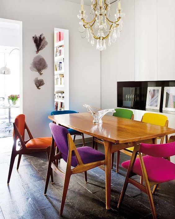 a stylish and cozy mid-century modern dining room with matching yet differently upholstered chairs