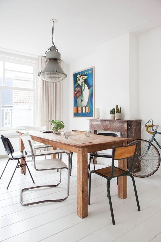 a chic dining space with a wooden table and mismatching chairs that make it evne more inviting and whimsy