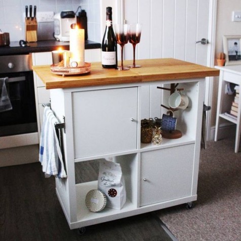 an IKEA Kallax turned into a mobile kitchen island with a wooden countertop and some closed compartments