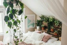 23 a crate shelf with potted plants and greenery and a cage with vines over the bed for a boho feel