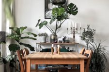 25 greenery in vases and pots and a green chair make the monochromatic dining room brighter and fresher