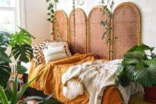 25 potted statement plants and some vines hanging over the bed make the bedroom feel tropical