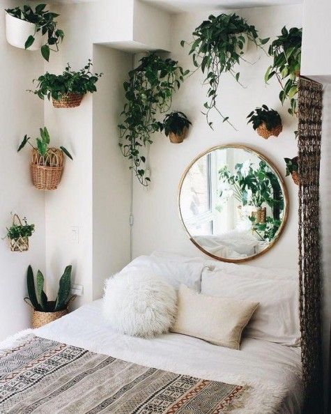 potted greenery in baskets attached to the wall over the bed refresh the space and make it bolder