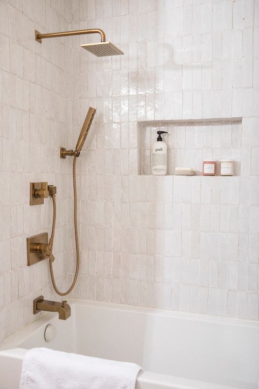 modern brass fixtures in the neutral bathroom make it chic and refined