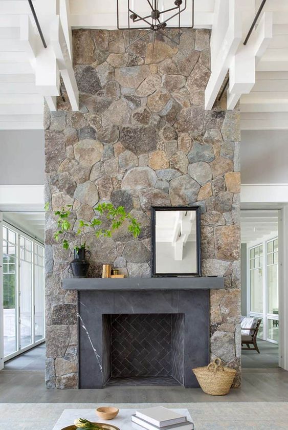 a large fireplace clad with beautiful stone and decorated with greenery will be a show-stopper in your room