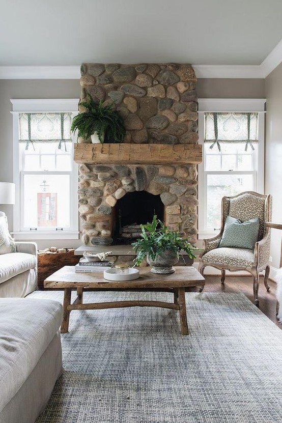 a refined vintage living room with a river rock fireplace that brings a touch of nature to the space