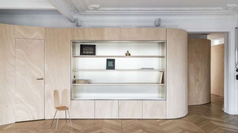 This wooden wall features some storage space, too, and it wraps the whole apartment dividing it into zones and keeping the historical touches seen