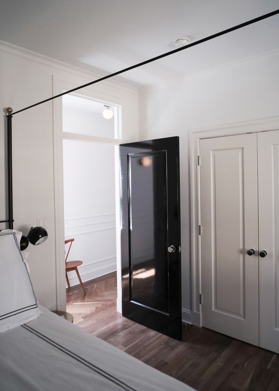 a glossy black door adds interest and chic to the neutral spaces and gives them a trendy feel