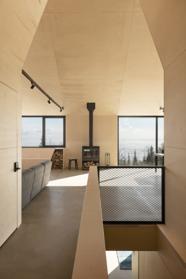Inside there are vast spaces all clad with light-colored plywood, with lots of windows and touches of black for drama