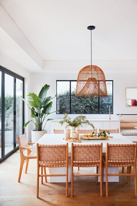 a Californian kitchen with a woven lamp, woven leather chairs and a large scale plant