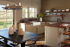 04 The kitchen is done with white wooden cabinets with wood countertops, there’s an eating space with dark furniture