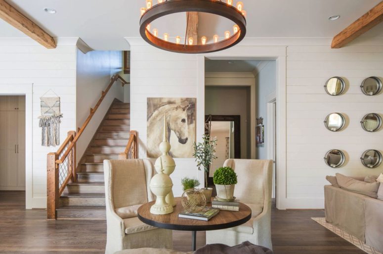 This cute sitting zone shows off two vintage chairs and is highlighted with a bold rustic chandelier, which is modern