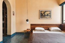 05 The bedroom is warmer, there’s a rich stained wooden bed, a tile floor and lamps