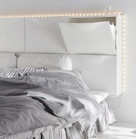 six white IKEA TRONES shoe cabinets are used to create a headboard with much storage